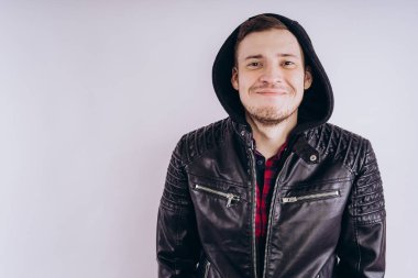 Deri ceketli genç erkek portresi üzerinde moda ceketli adam kadar zipping ve beyaz arka plan üzerinde kamera gülümseyerek