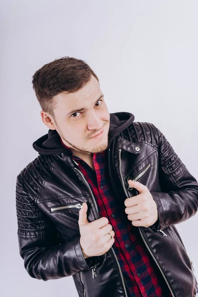 Man in trendy jacket on white backgroundPortrait of young male in leather jacket zipping up and smiling at camera on white background