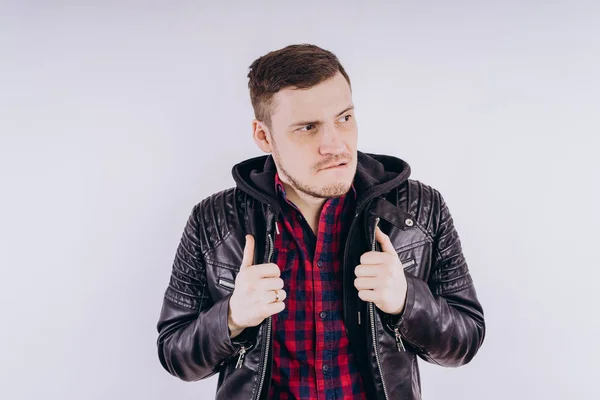 Man in trendy jacket on white backgroundPortrait of young male in leather jacket zipping up and smiling at camera on white background