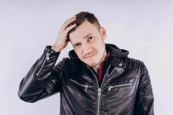 Man in trendy jacket on white backgroundPortrait of young male in leather jacket zipping up and smiling at camera on white background