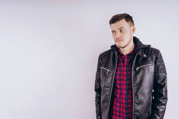 Man in trendy jacket on white backgroundPortrait of young male in leather jacket zipping up and smiling at camera on white background