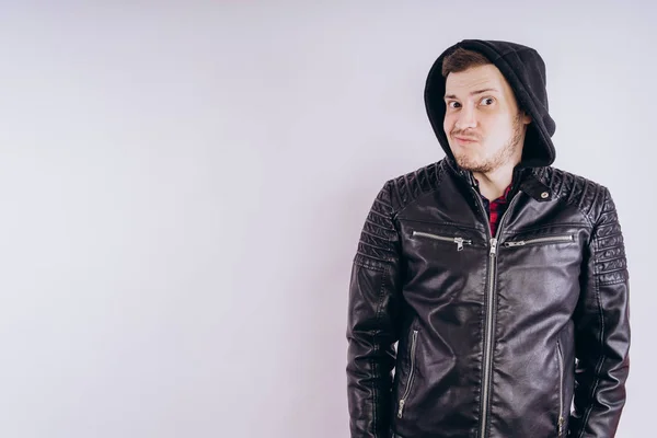 Man in trendy jacket on white backgroundPortrait of young male in leather jacket zipping up and smiling at camera on white background