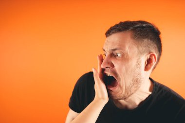 Turuncu arka plana tokat yiyorum mutsuz korkmuş adam turuncu arka planda ayakta tokatlanıyor