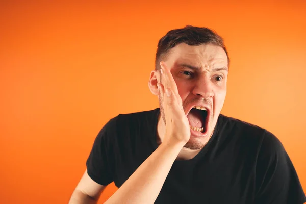 Man getting slapped on orange backgroundUnhappy scared man getting slapped standing on orange background