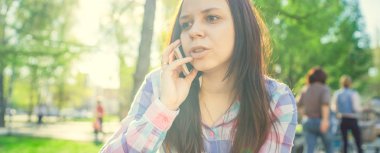 Akıllı telefon kullanan genç bir kadın.  