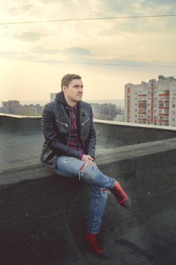  Genç adam çatıda günlük giysiler içinde.
