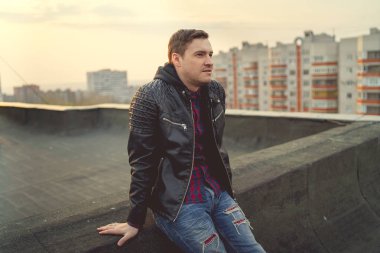  Genç adam çatıda günlük giysiler içinde.