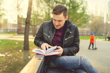 Park yerinde kırmızı defterli bir adam var.