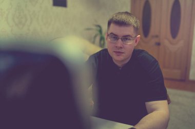 Bilgisayardaki genç adam, dizüstü bilgisayarda çalışıyor.