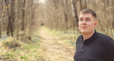 Bir adam sonbahar ormanında poz verir..