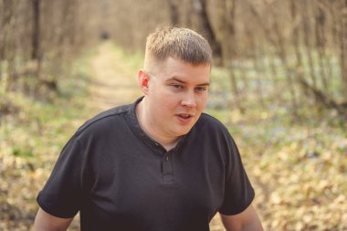 Bir adam sonbahar ormanında poz verir..