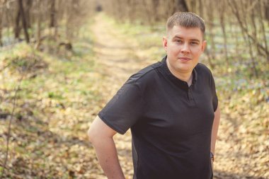 Bir adam sonbahar ormanında poz verir..