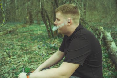 Bir adam elektronik sigara içiyor.