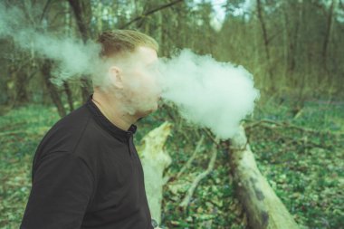 Bir adam elektronik sigara içiyor.