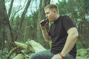 Bir adam elektronik sigara içiyor.