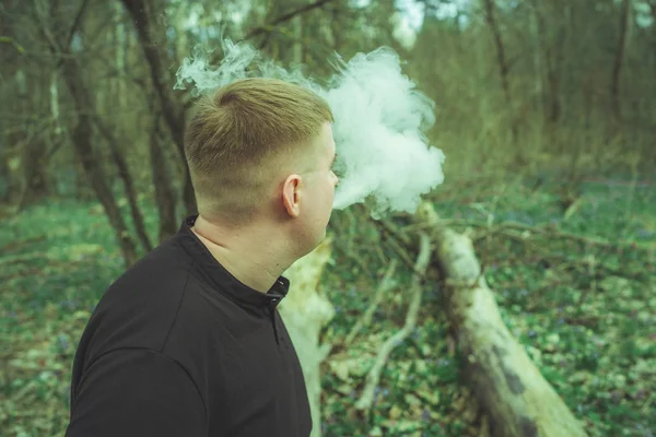 Bir adam elektronik sigara içiyor.