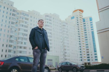 Şehirde poz veren bir adam.