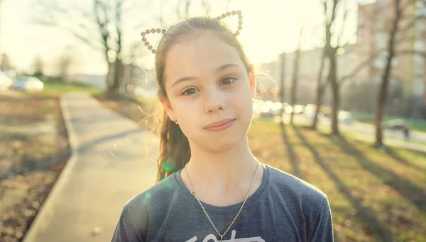 Retrato de uma menina em roupas casuais está de pé no parque infantil — Fotografia de Stock