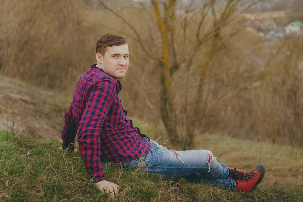 Young Man Sitting Green Hill Side View Young Male Jeans — Stock Photo, Image