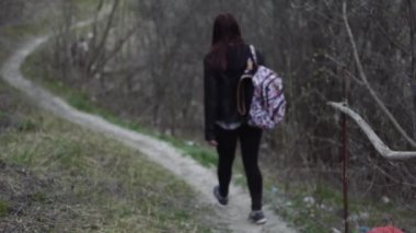 Sırt çantalı genç bayan turist dışarıda yürüyor.