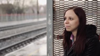 Tren istasyonunda düşünceli bir kadın 