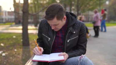 Parkta defteri olan bir adam.