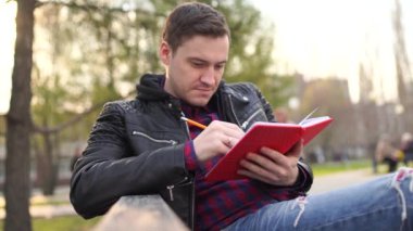 Parkta defteri olan bir adam.