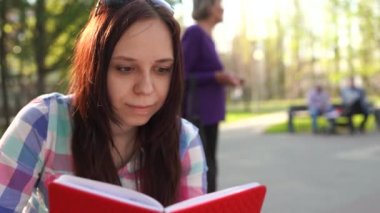 Kadınların elleri sokakta kırmızı bir defter tutuyor.