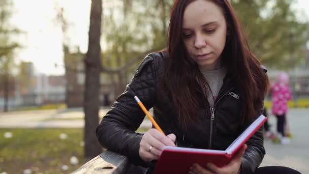 Mujer Escribiendo Notas Cuaderno Rojo Calle — Vídeo de stock