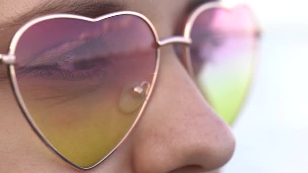 遠くを見ながら色合いを身に着けている若い女性 女性の顔にサングラスのクローズアップとメガネで水の反射 晴れた日 太陽紫外線からの目の保護 — ストック動画