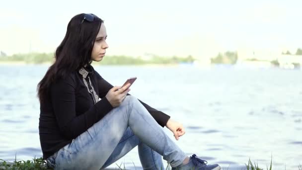 Una Bella Mujer Que Utiliza Teléfonos Inteligentes Orillas Del Río — Vídeos de Stock