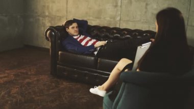 Terapistlerde üzgün bir adam. Kadın psikolog hastaya yardım eder. Psikolog alma