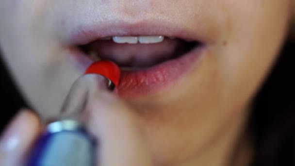 Woman paints her lips close-up, macro shooting. Woman paints her lips with red lipstick. Female face, mouth closeup, woman beauty makeup — Stock Video
