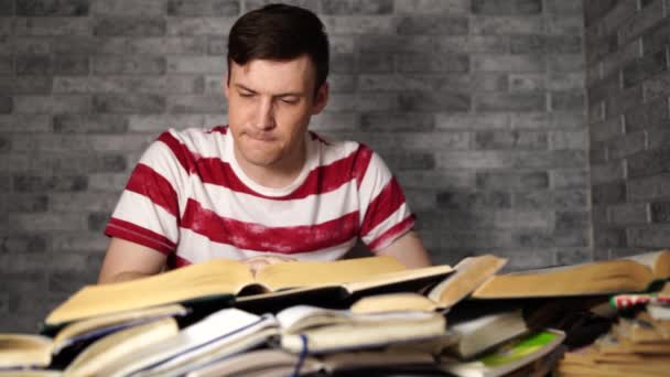 Άνθρωπος φοιτητής βαρετό βιβλίο ανάγνωσης στη βιβλιοθήκη με πολλά βιβλία στο Πανεπιστήμιο. Φοιτητής αποκαρδιωμένο διαβάζοντας βιβλίο για την εξέταση. — Αρχείο Βίντεο