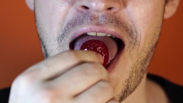 Un uomo mangia una fragola, uomini bocca primo piano . — Video Stock