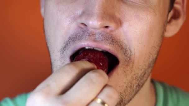 Mężczyzna zjada truskawka, usta mężczyzn zbliżenie. — Wideo stockowe