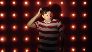 Şaşkın erkek tırmalama kafası. Şaşkın bir genç adam kafasını çizmeye