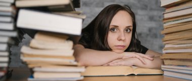 Masada bir sürü kağıt kitap ile okuyan güzel kadın öğrenci