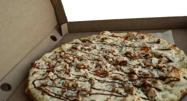 Zbliżenie pizzy, w tekturowym pudełku nad stołem — Zdjęcie stockowe