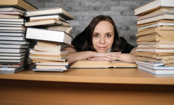 Stock image Beautiful woman student studying with a lot of paper books on the table