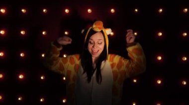 Parlak çocuklu bir kadın zürafa şeklinde pijama, dans ediyor. bir öğrencinin duygusal portresi. çocuk animatör kostümlü sunumu. Kostümlü dans eden bir kadın
