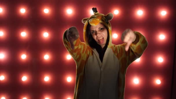 Bloggerin zeigt Abneigung gegen Handbewegungen. eine Frau in leuchtenden Kinderpyjamas in Form eines Kängurus. Emotionales Porträt einer Studentin. — Stockvideo