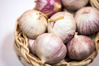 Beyaz bir arka plan üzerinde, hasır sepet içinde sarımsak. Kurutulmuş Fransız sarımsağı. Kırmızı sarımsak.