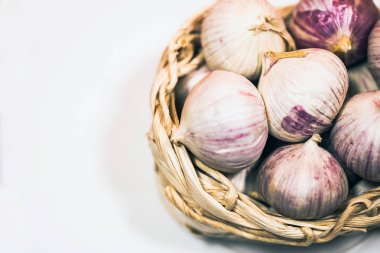 Beyaz bir arka plan üzerinde, hasır sepet içinde sarımsak. Kurutulmuş Fransız sarımsağı. Kırmızı sarımsak.