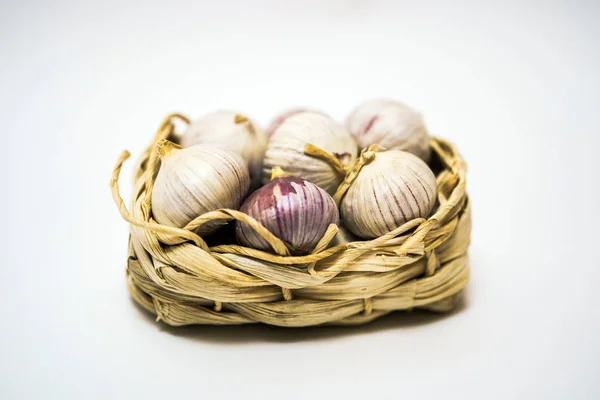 Knoflook in een rieten mand, op een witte achtergrond. Gedroogde Franse knoflook. Rode knoflook. — Stockfoto