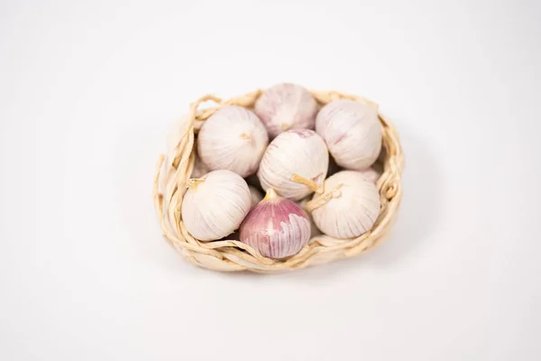 Fokhagymát egy fonott kosár, fehér alapon. Szárított francia fokhagyma. Vörös fokhagyma. — Stock Fotó