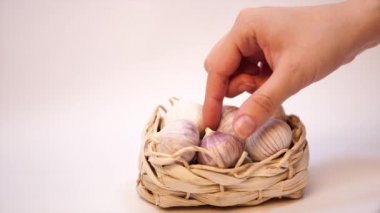 Beyaz bir arka plan üzerinde, hasır sepet içinde sarımsak. Kurutulmuş Fransız sarımsağı. Kırmızı sarımsak.