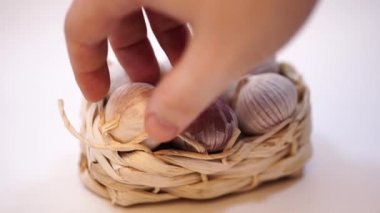 Beyaz bir arka plan üzerinde, hasır sepet içinde sarımsak. Kurutulmuş Fransız sarımsağı. Kırmızı sarımsak.