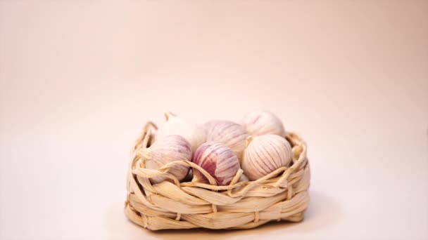 Garlic in a wicker basket, on a white background. Dried French garlic. Red garlic. — Stock Video