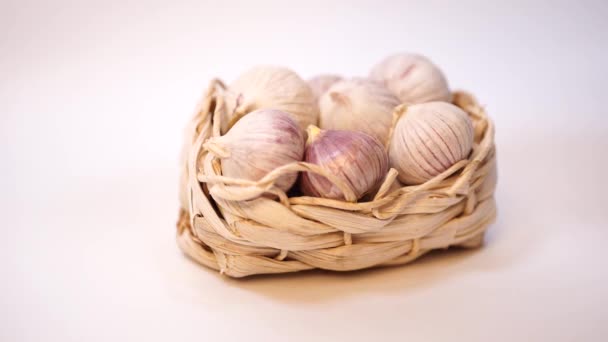 大蒜在柳条篮子里，在白色背景上。干法国大蒜。红蒜. — 图库视频影像